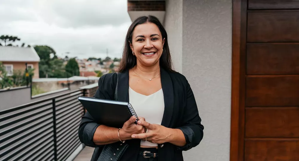 Latina woman smiling with notebook in her hand
