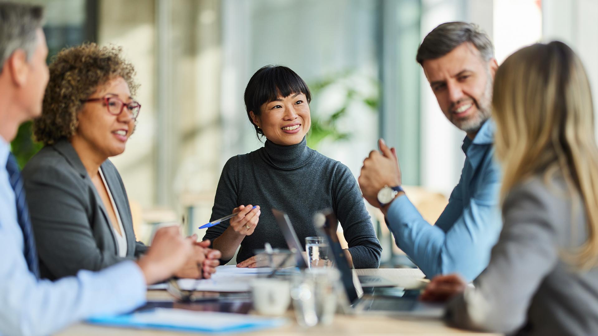 Group of professional coworkers meeting together and smiling