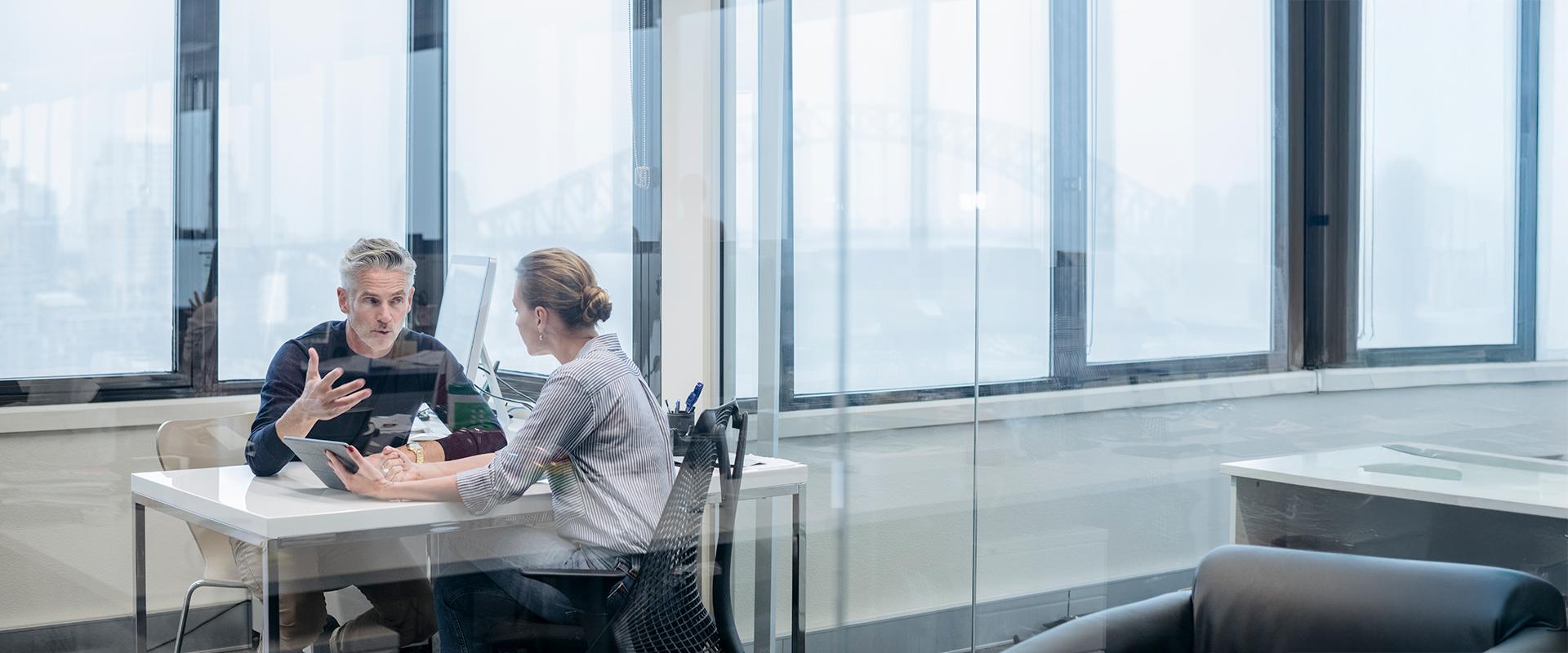 Male and female colleagues sitting and talking together in the office