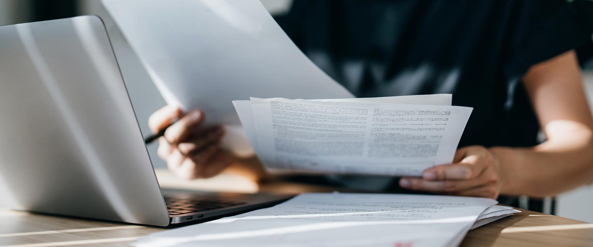 Woman sifting through papers at her desk