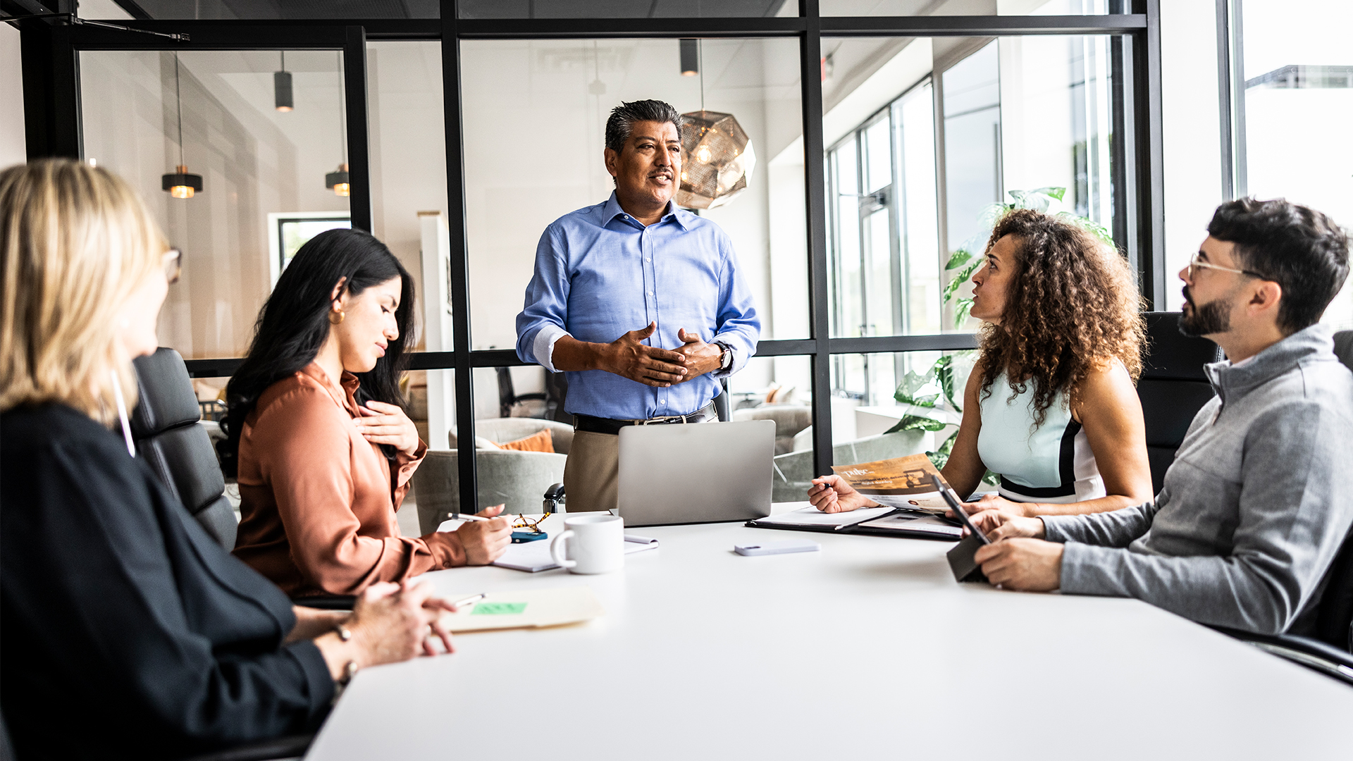 Middle aged man standing a presenting in a work meeting