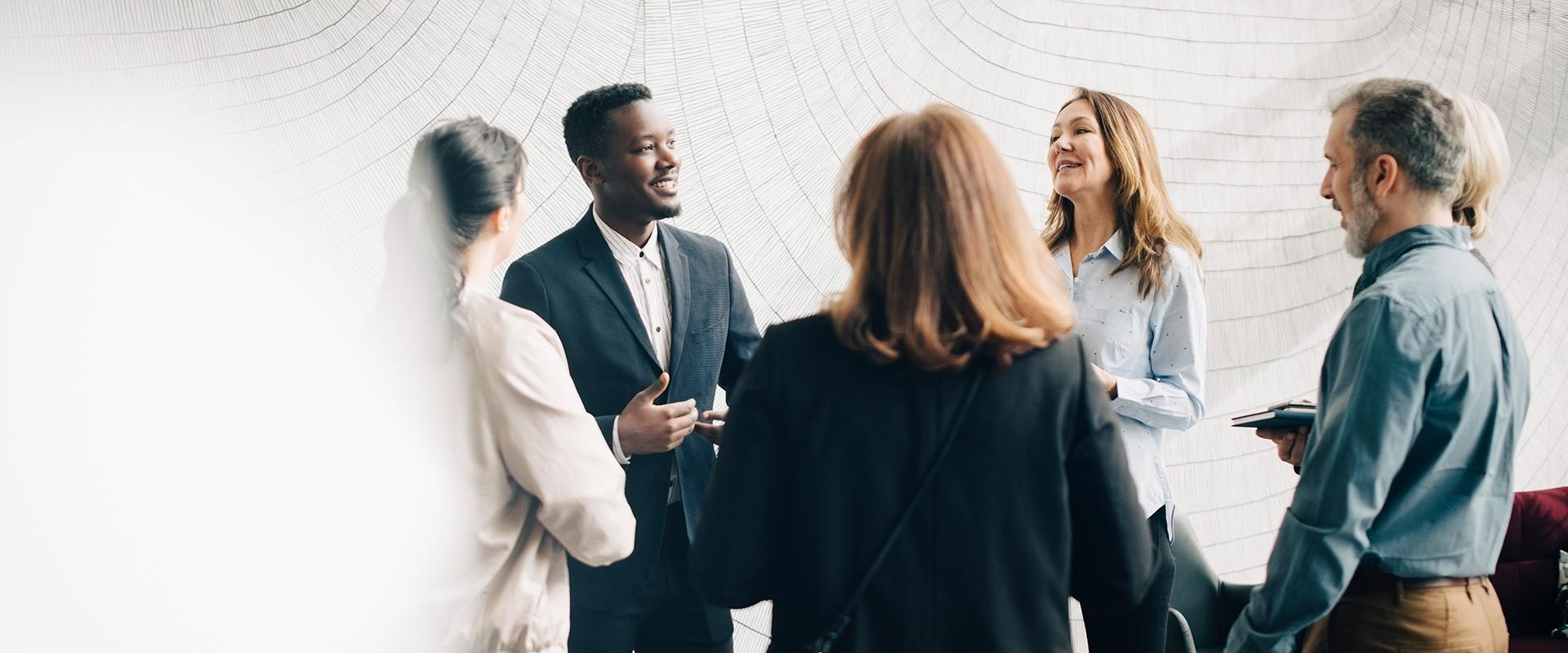 Diverse group of colleagues speaking together in a circle 