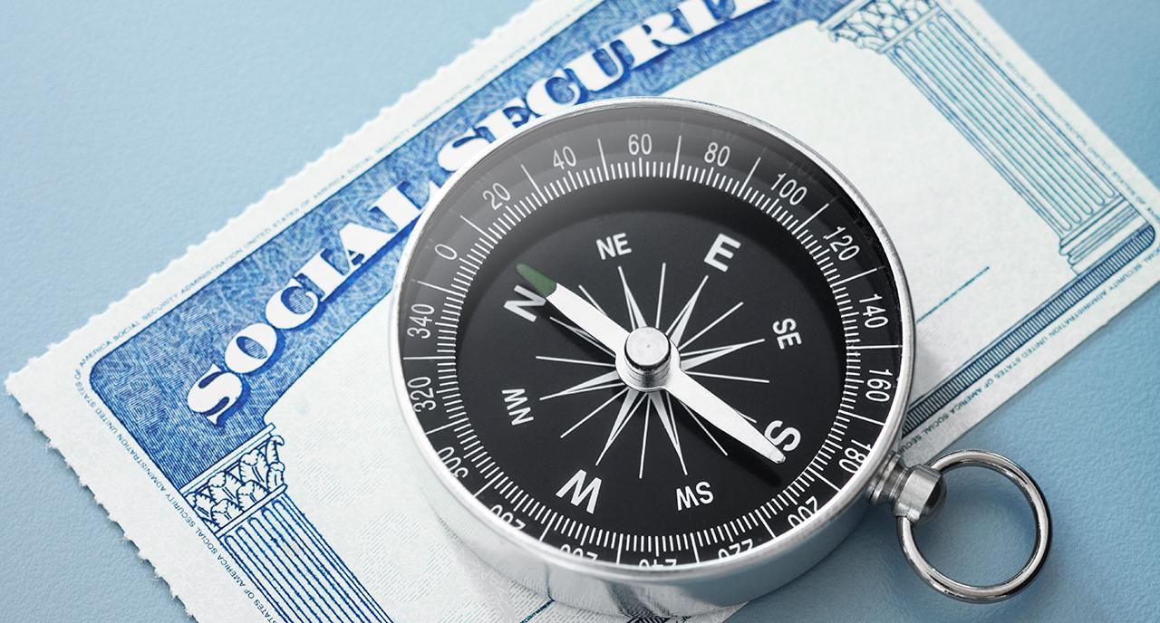 A compass laying on top of a social security card