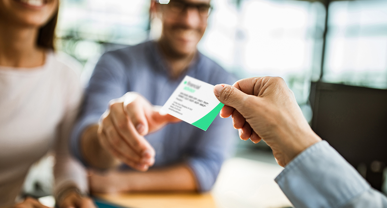 Advisor handing out their business card to a client