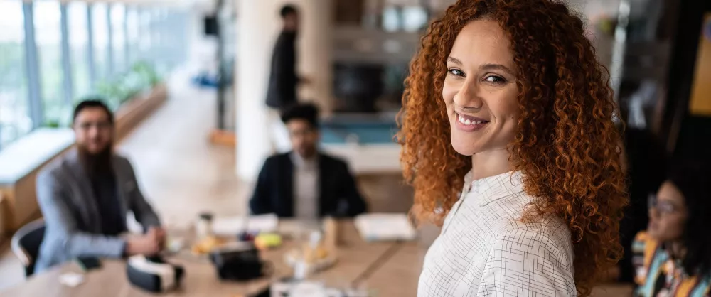 Chartered Leadership Fellow smiling in the office conference room