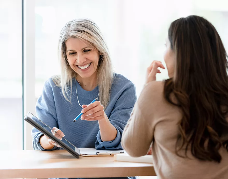 Two women talking and looking at a table