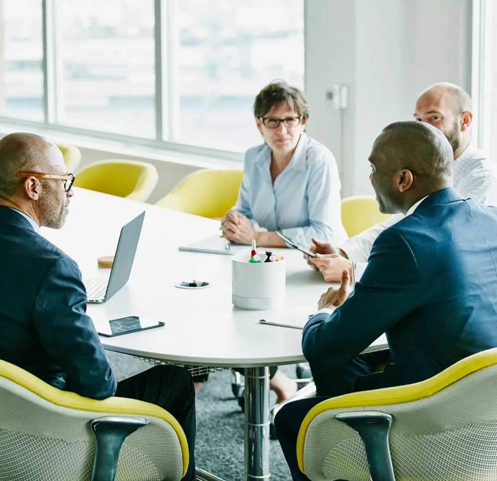 Financial professionals sitting in a board room talking