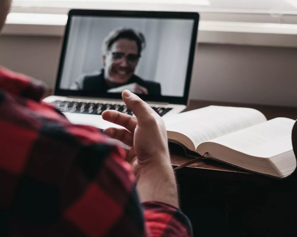 Person sitting at desk watching video on computer.