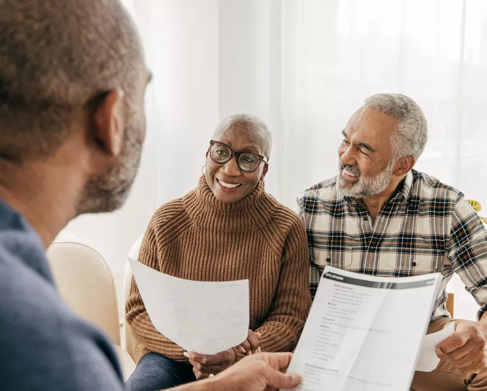 A couple talking to a man and looking at documents