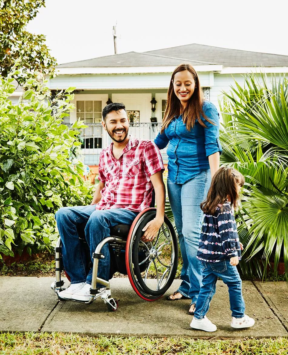 Parents smiling in front of home with child