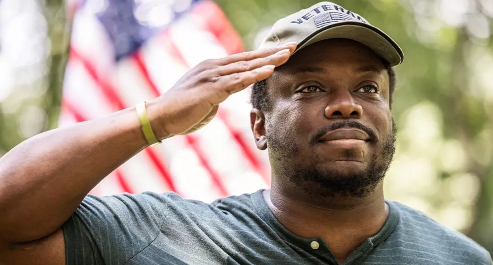 Veteran giving a salute in front of the American Flag