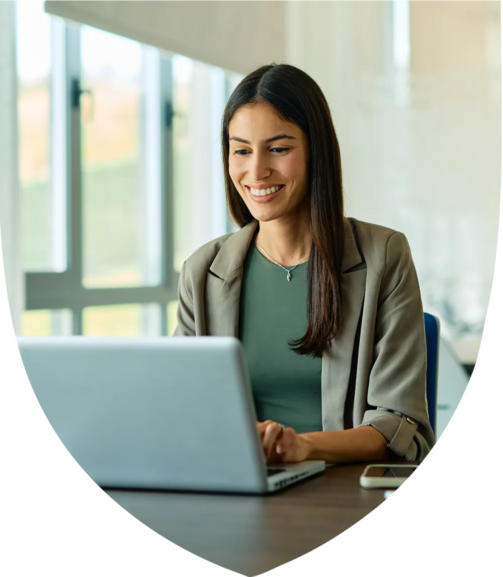 Young female professional smiling on while working on her laptop