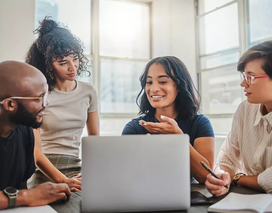 Group of four young professionals learning on the computer together