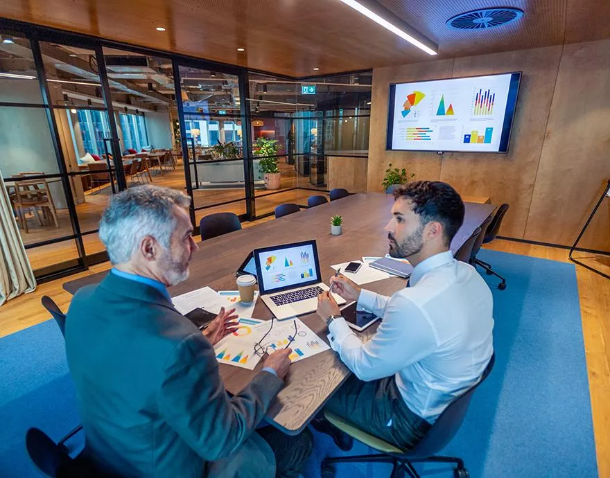 Two coworkers meeting in the boardroom