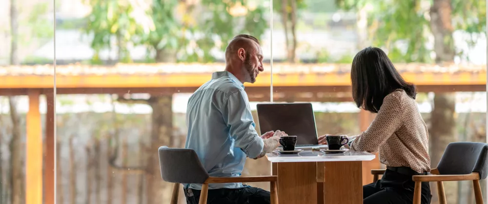 Two professionals sitting down advance their careers at the College