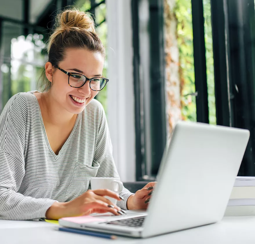 Smiling female student browsing on her laptop