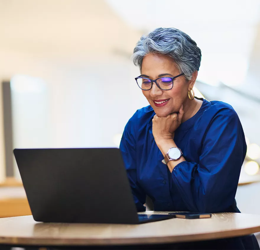 Elder woman browsing retirement options on her laptop