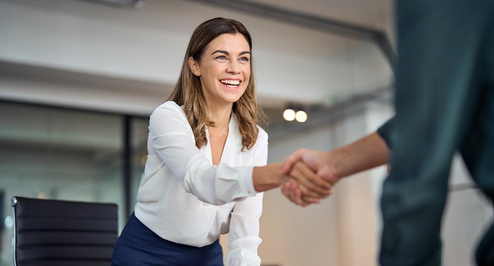 Female and male financial professionals shaking hands