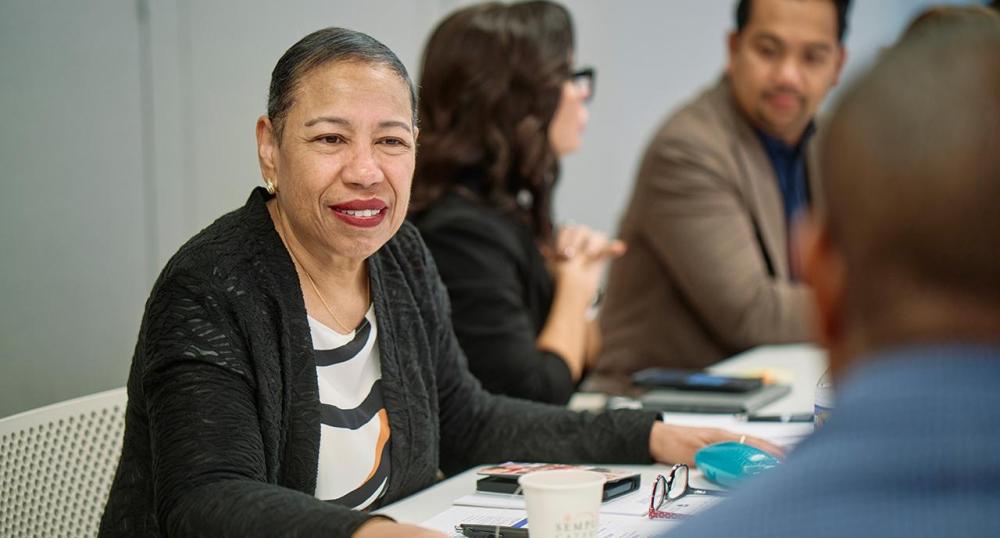 Angie Ribuffo sitting at a table with conference attendees