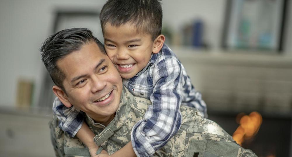 Military dad and his son playing