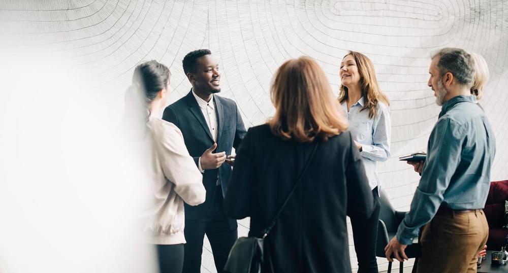 Diverse group of colleagues speaking together in a circle 