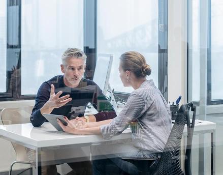 Male and female colleagues sitting and talking together in the office